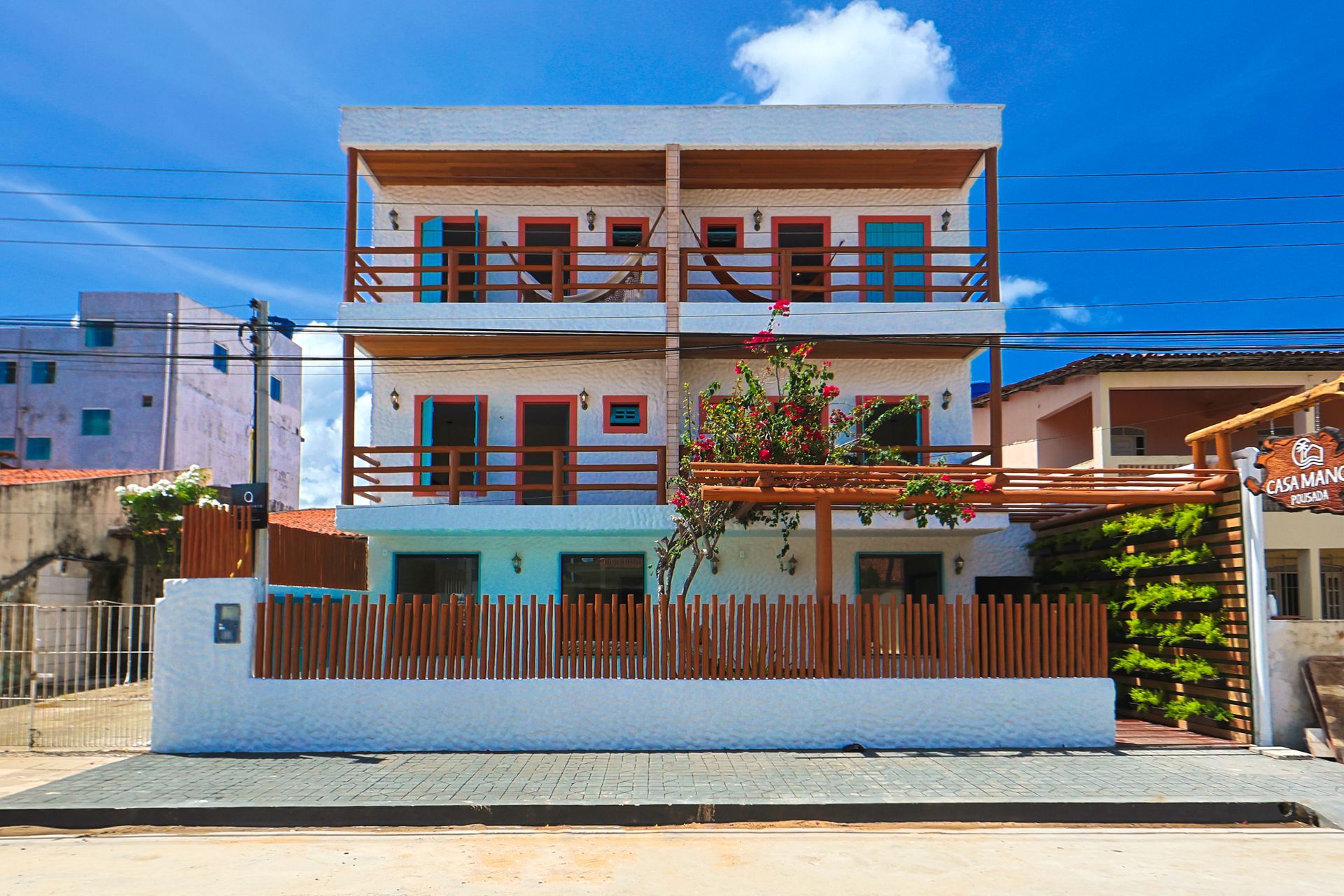 Um grande edifício branco com uma cerca de madeira na frente