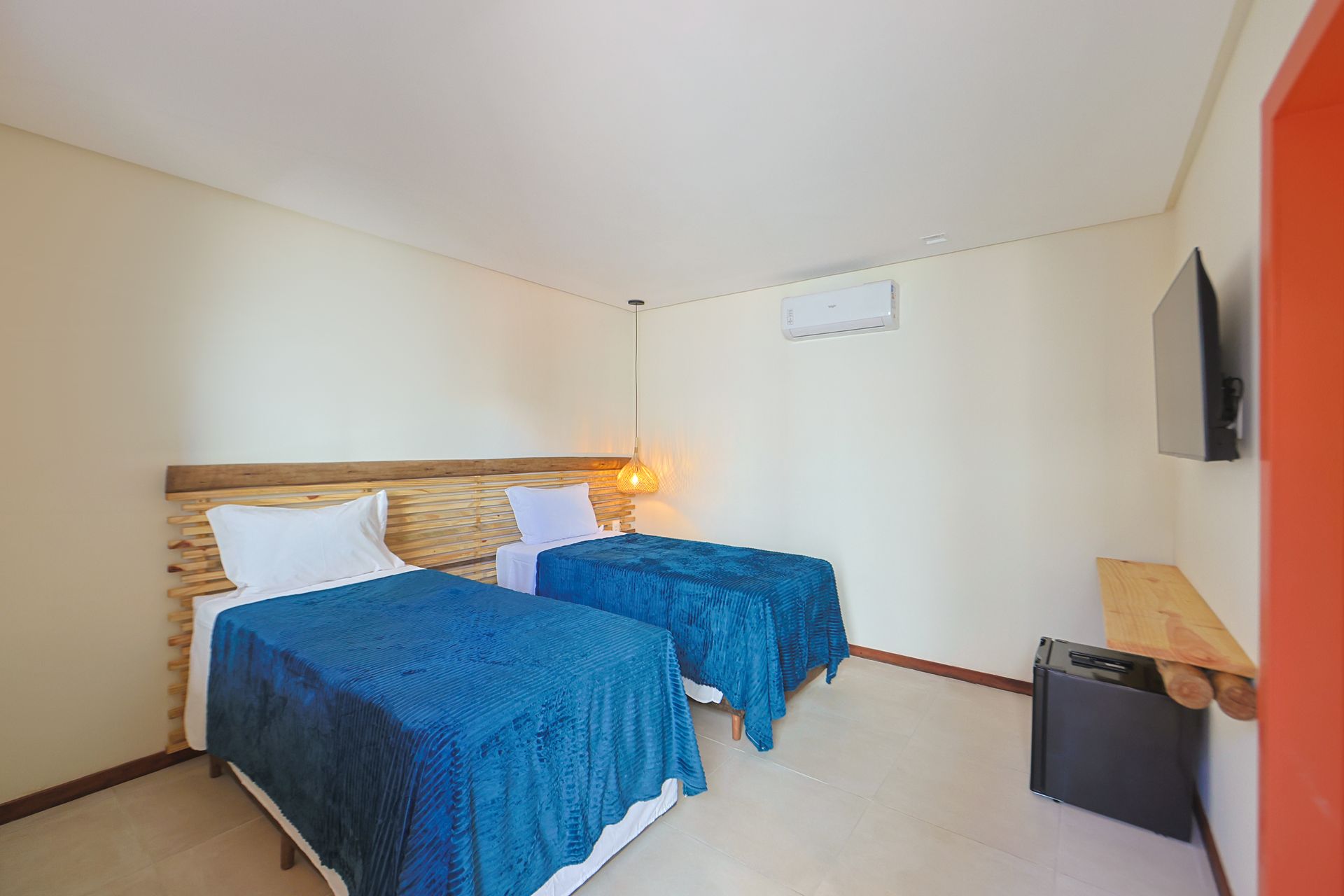 Um quarto de hotel com duas camas e uma TV de tela plana.