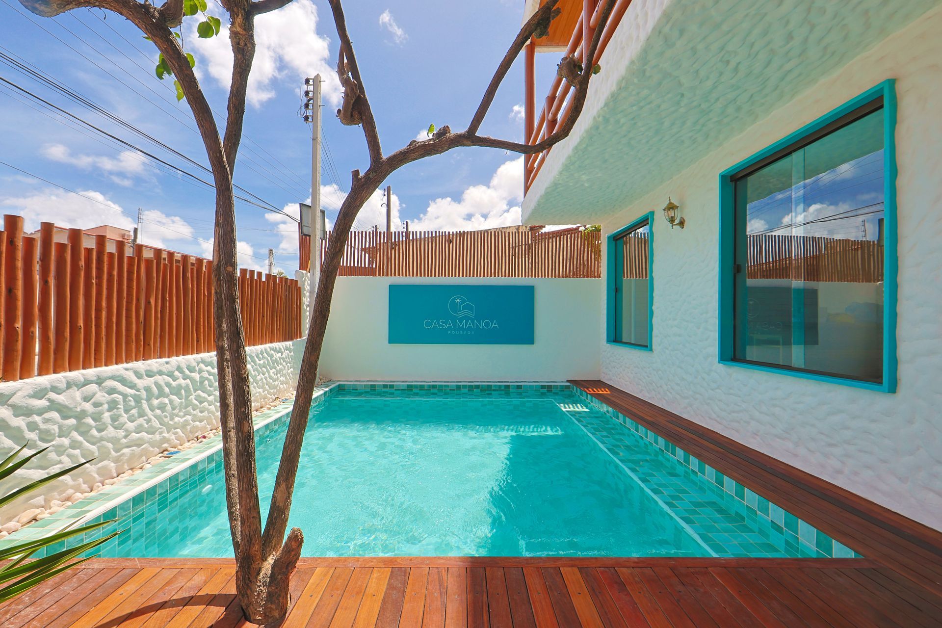 Uma grande piscina é cercada por um deck de madeira e uma cerca.