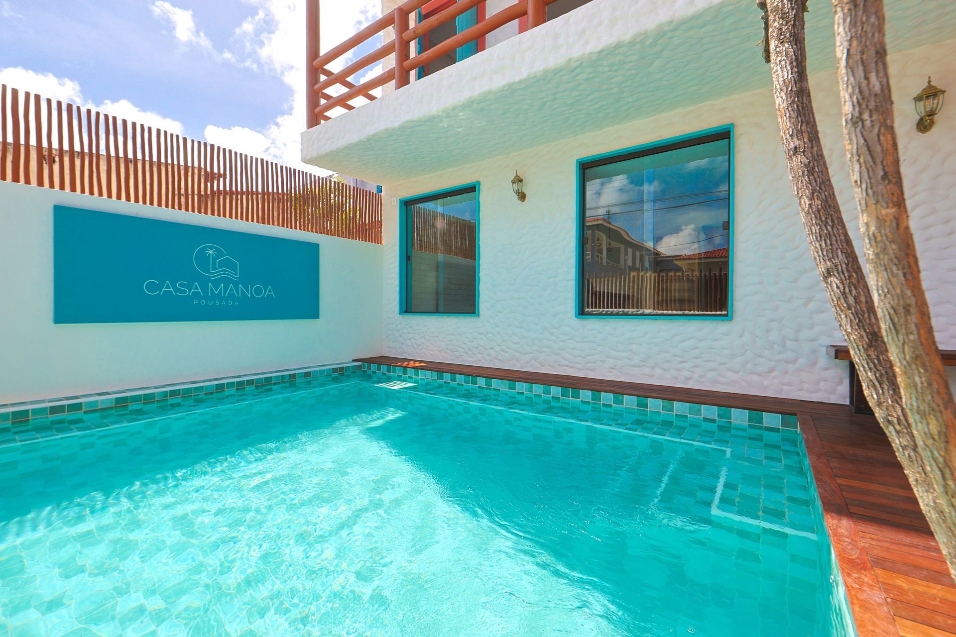 Há uma grande piscina em frente a uma casa.