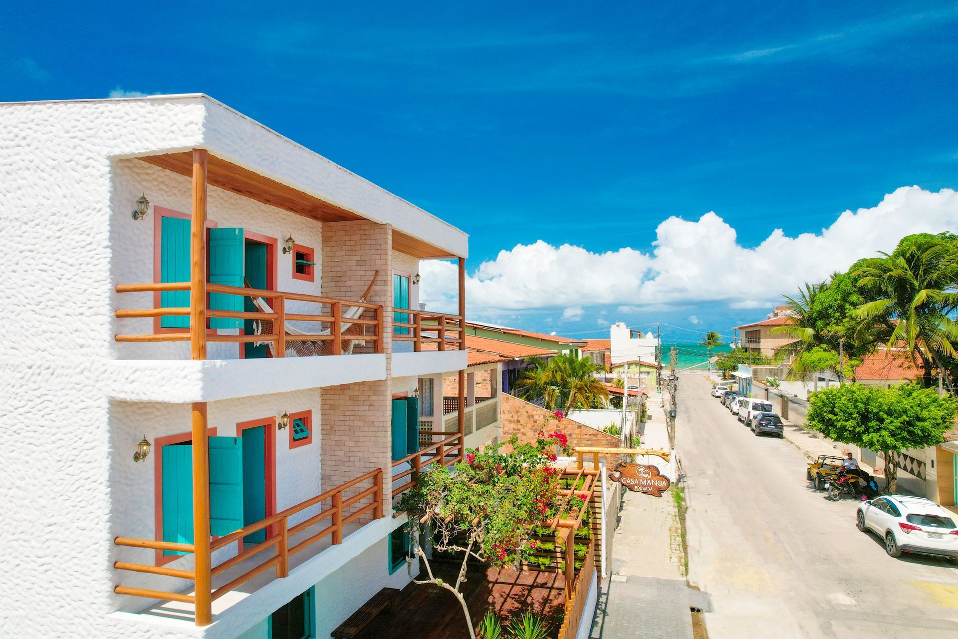 Uma vista aérea de um edifício branco com portas e varandas azuis