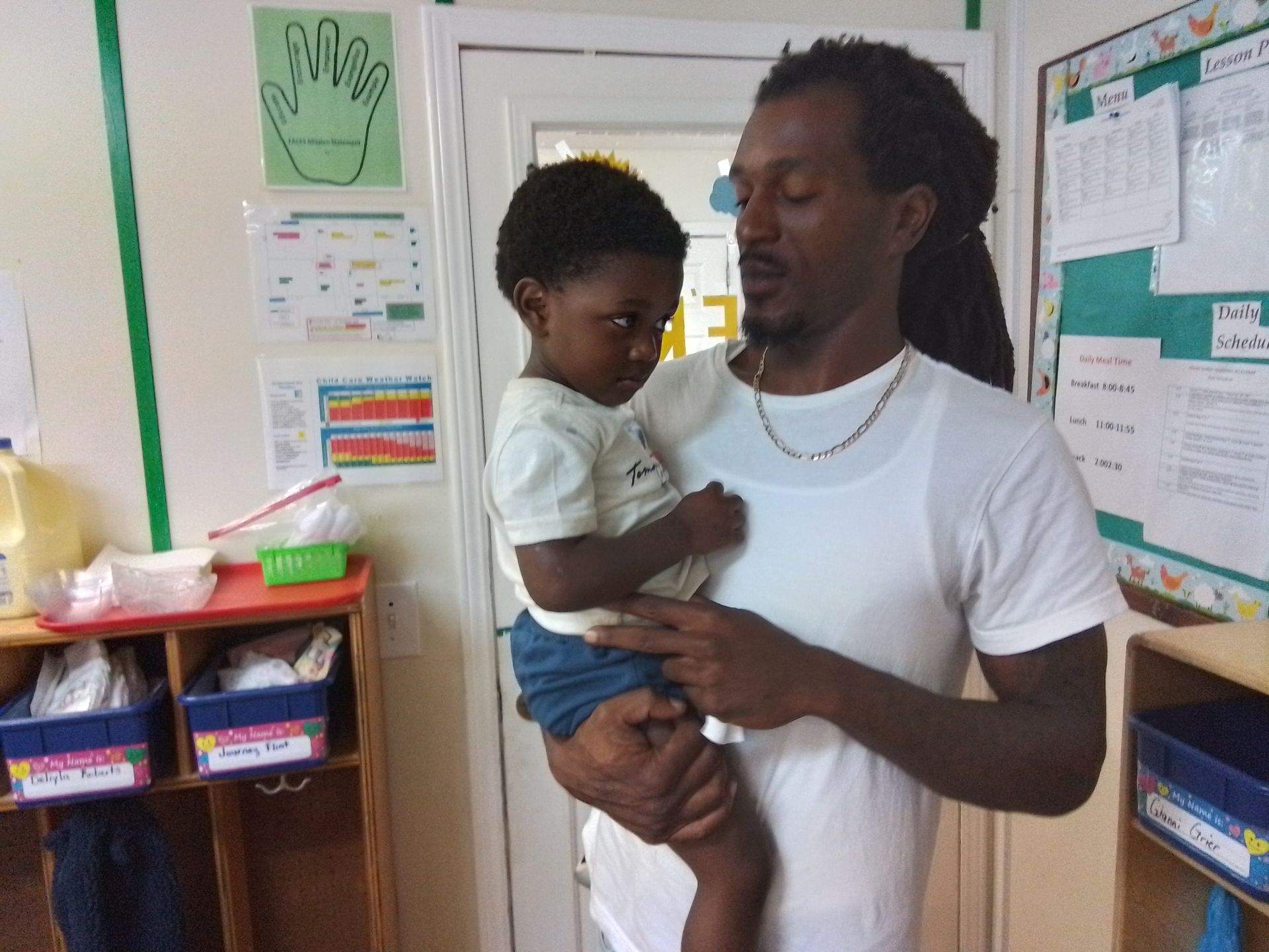 A group of children are sitting on the grass with a teacher.