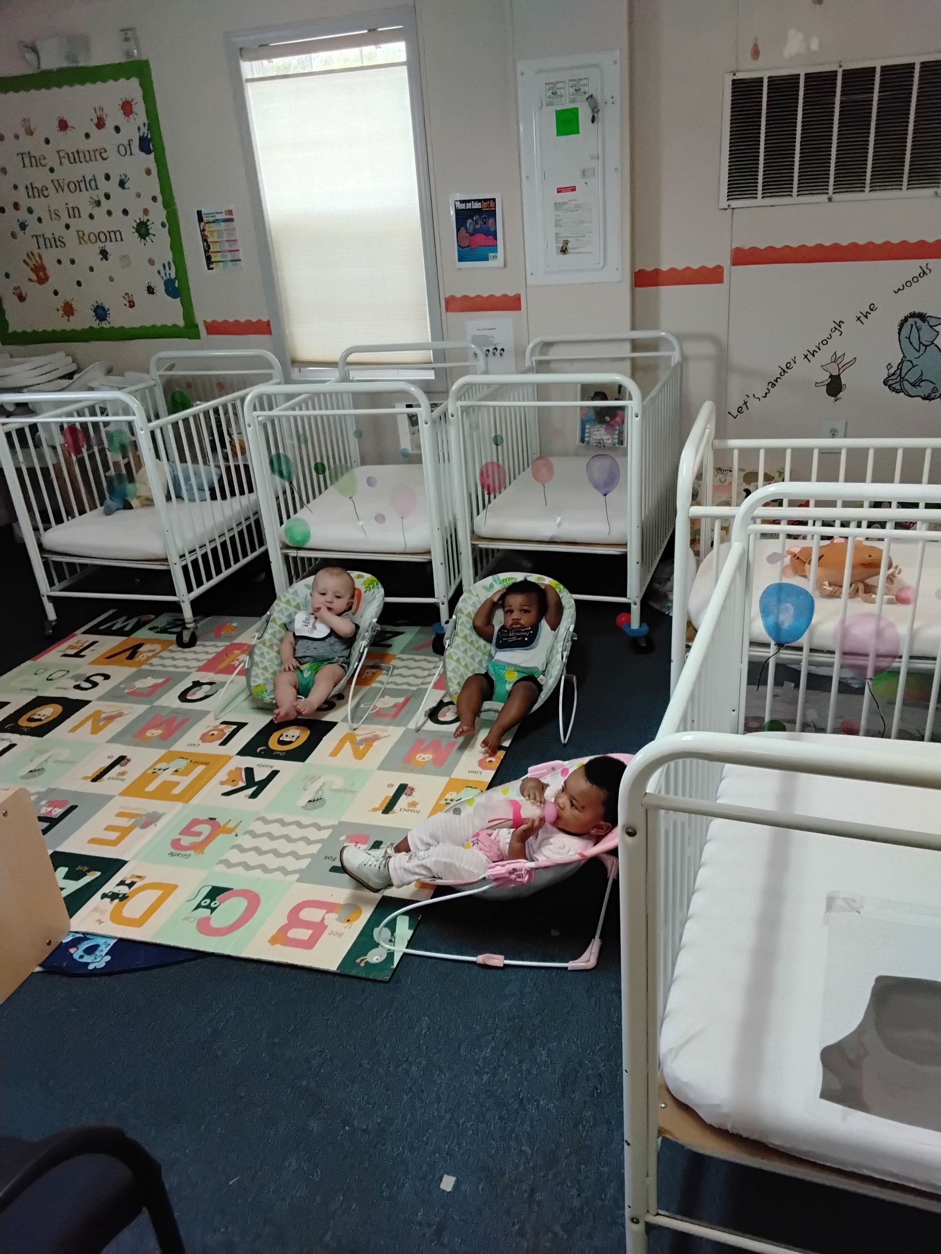 Three babies are sitting on the floor playing with toys.