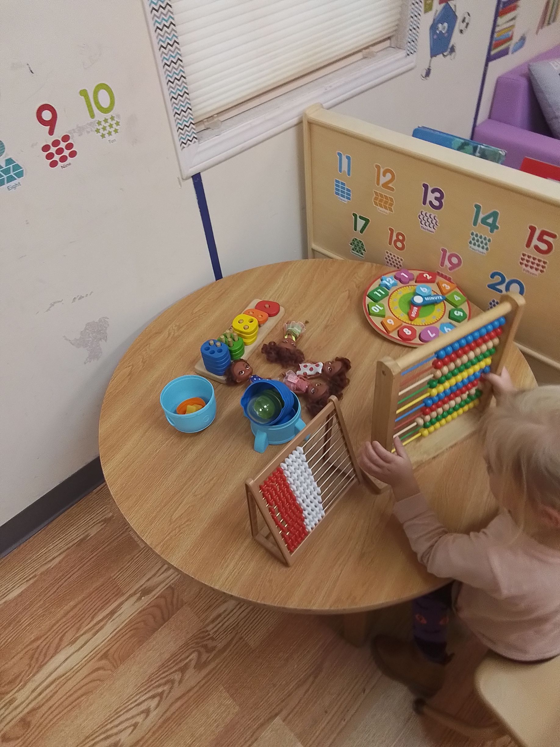 Three little girls are sitting on a couch reading a book together.