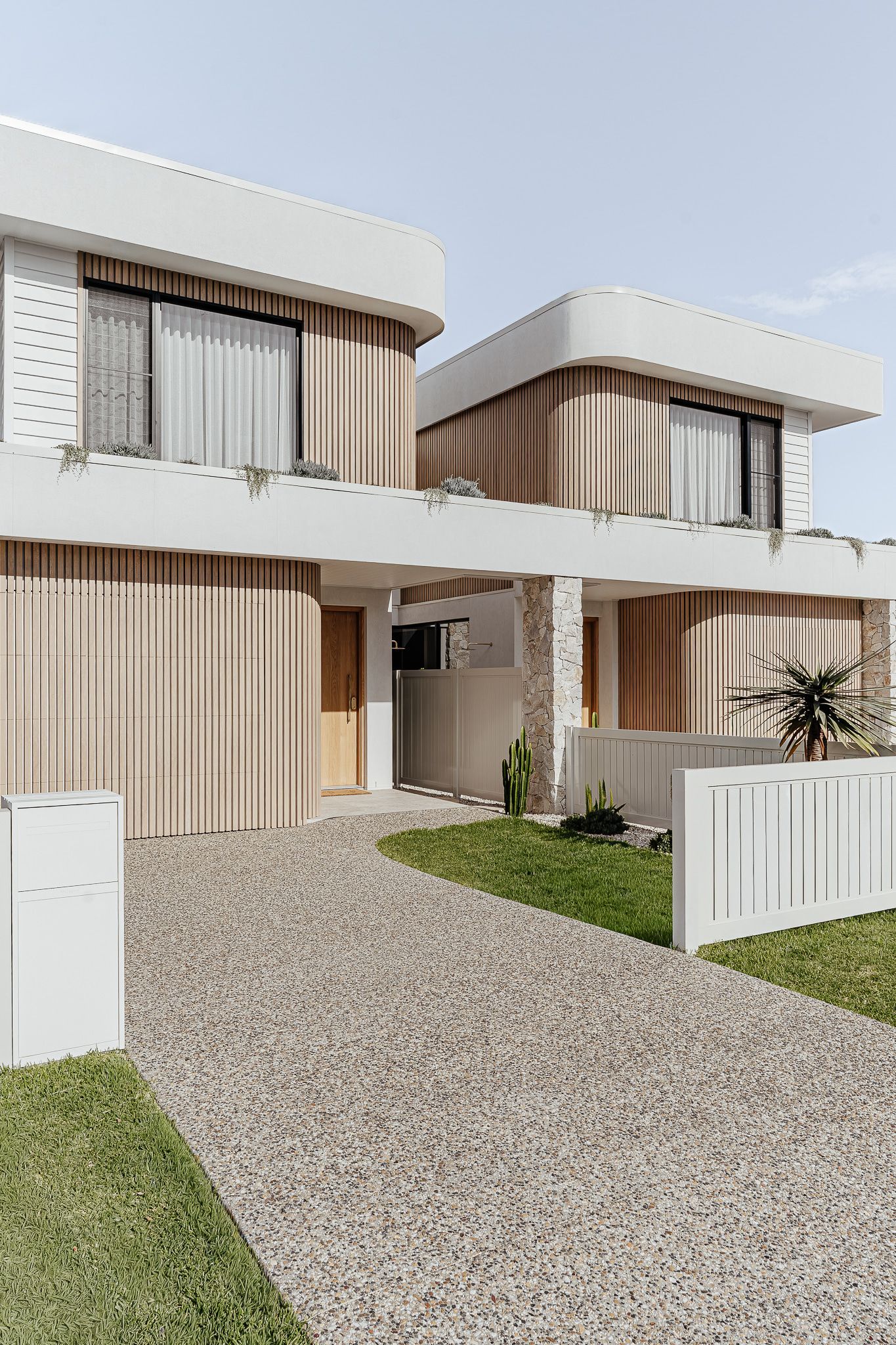 Modern Two-story Homes With Light Brown Vertical Siding, White Trim, and a Curved Roof — SDC Building Design In Kiama, NSW