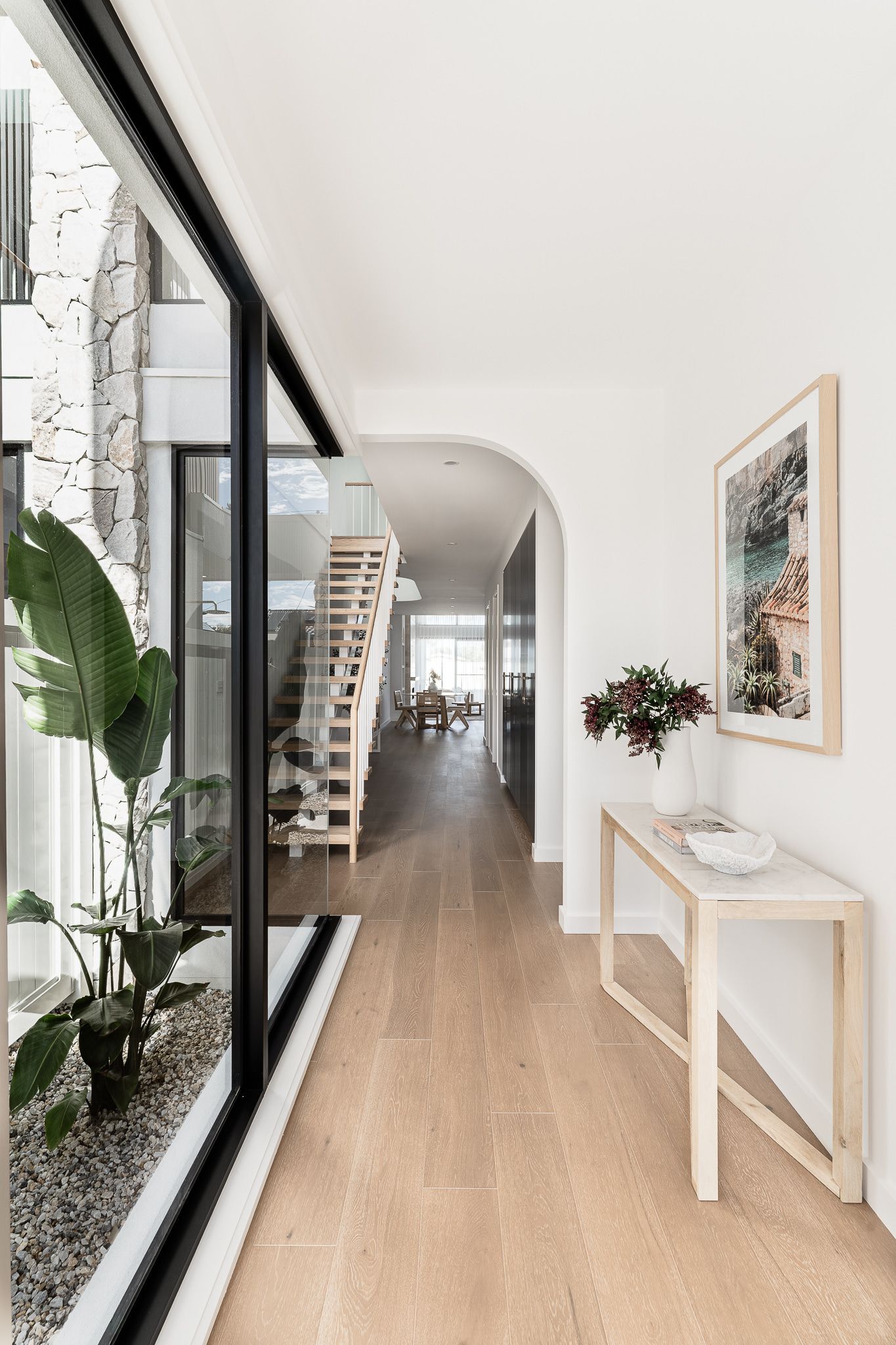 Hallway With Wooden Floors, Large Window, Staircase, and Minimalist Decor — SDC Building Design In Kiama, NSW