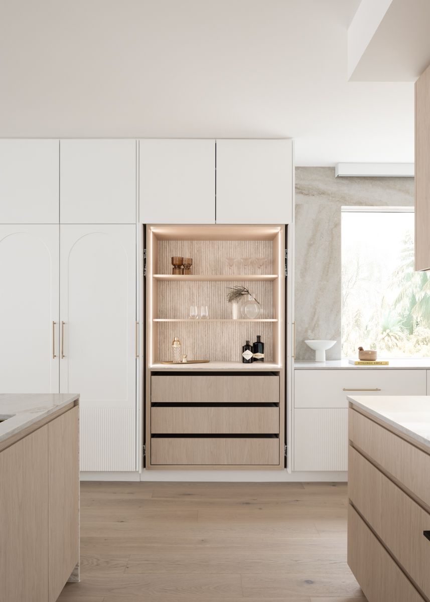 Modern kitchen with built-in storage. Light wood and white cabinets with a lit display area. — SDC Building Design In Kiama, NSW
