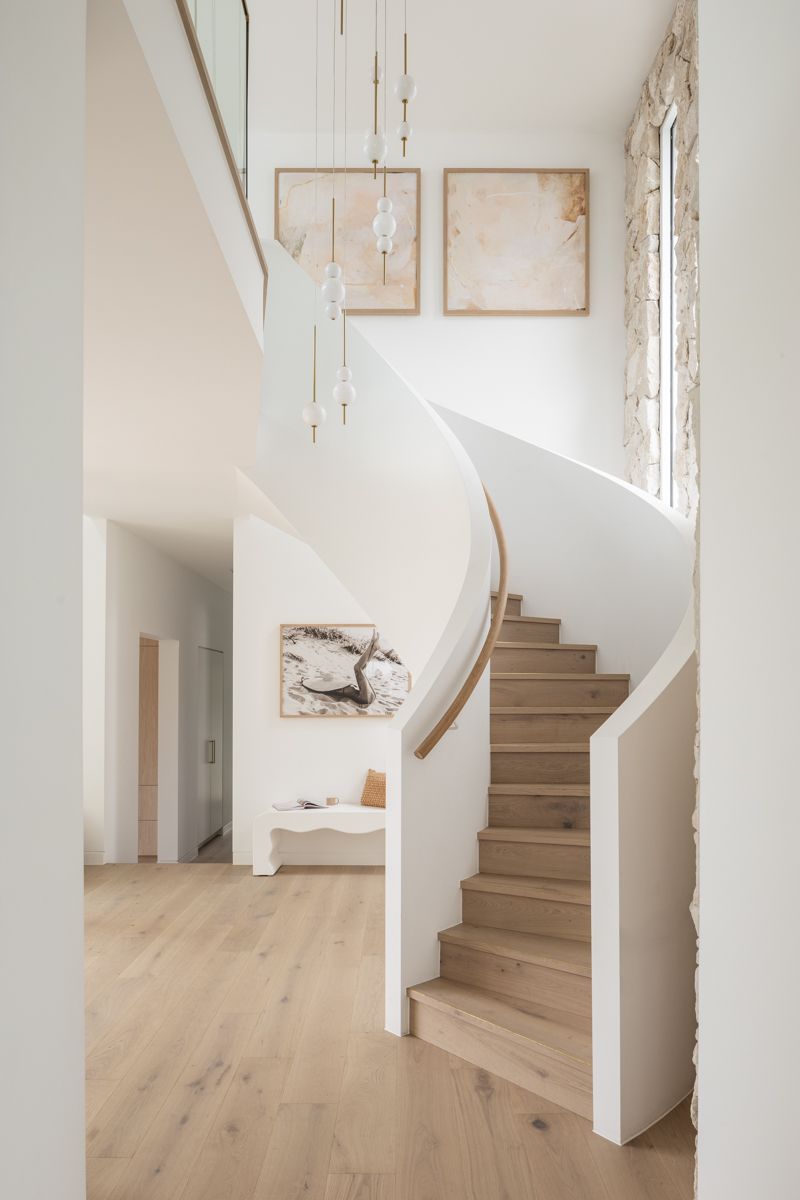 Wooden staircase with white walls, artwork, and pendant lights in a modern interior. — SDC Building Design In Kiama, NSW