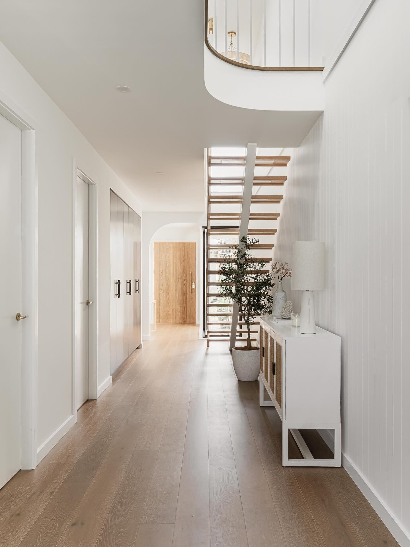 Hallway With Wooden Floor, White Walls, and a Staircase Leading Upstairs — SDC Building Design In Kiama, NSW