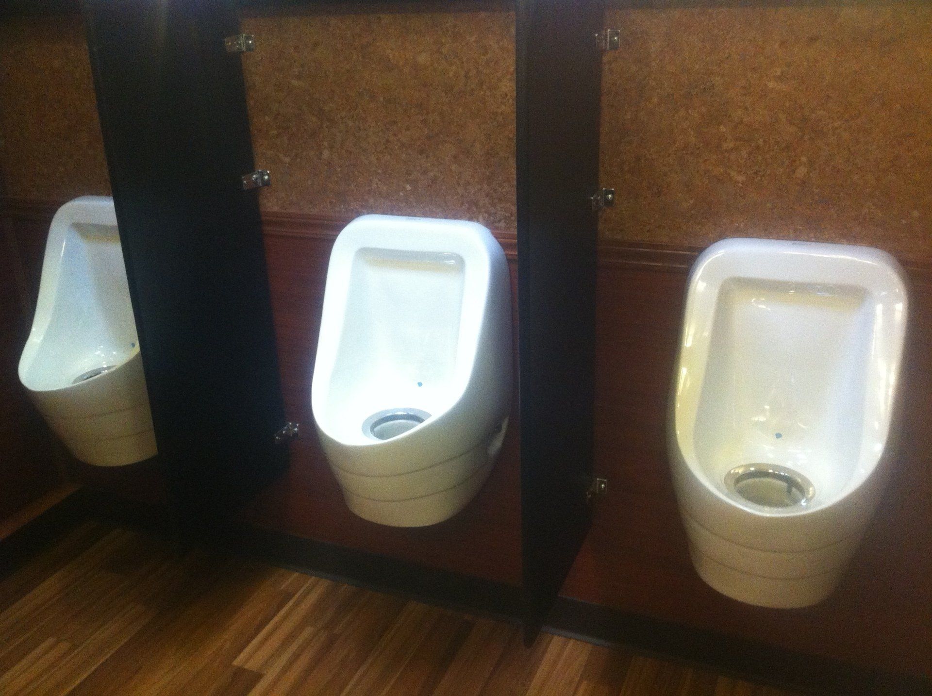 Three urinals are lined up next to each other in a public restroom.