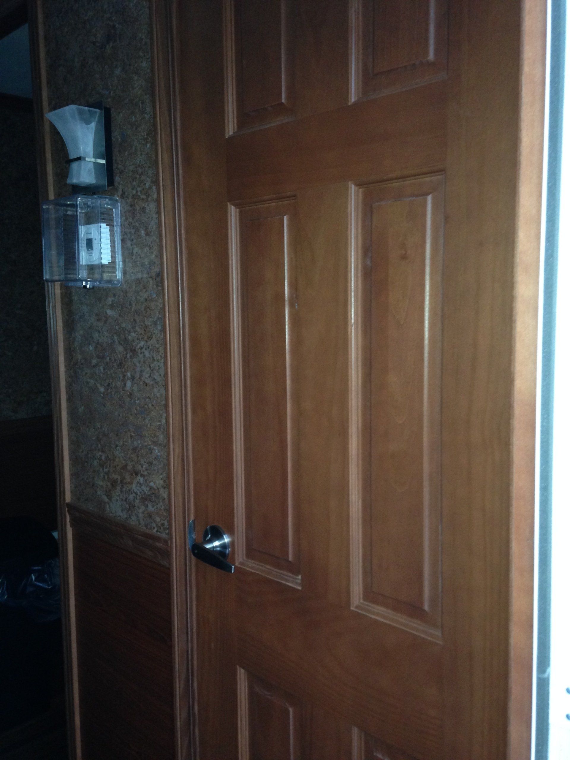 A wooden door is open to a dark room