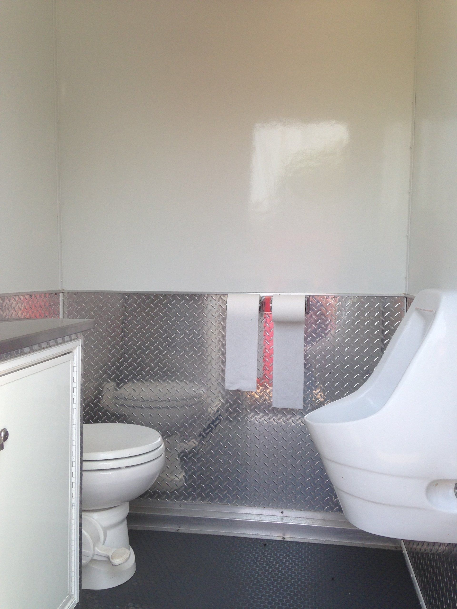 A bathroom with a toilet and urinal in it