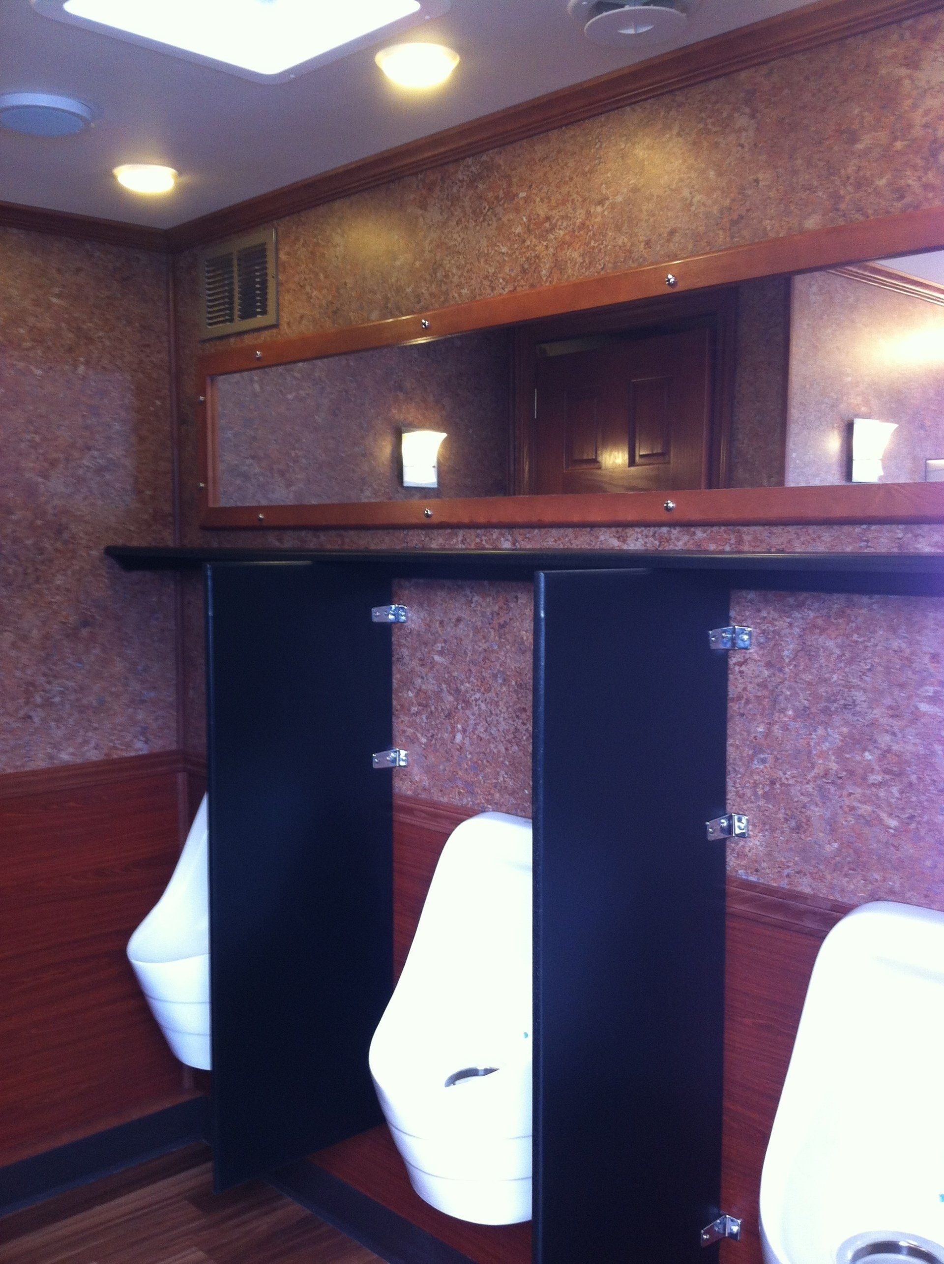 A bathroom with two urinals and a mirror