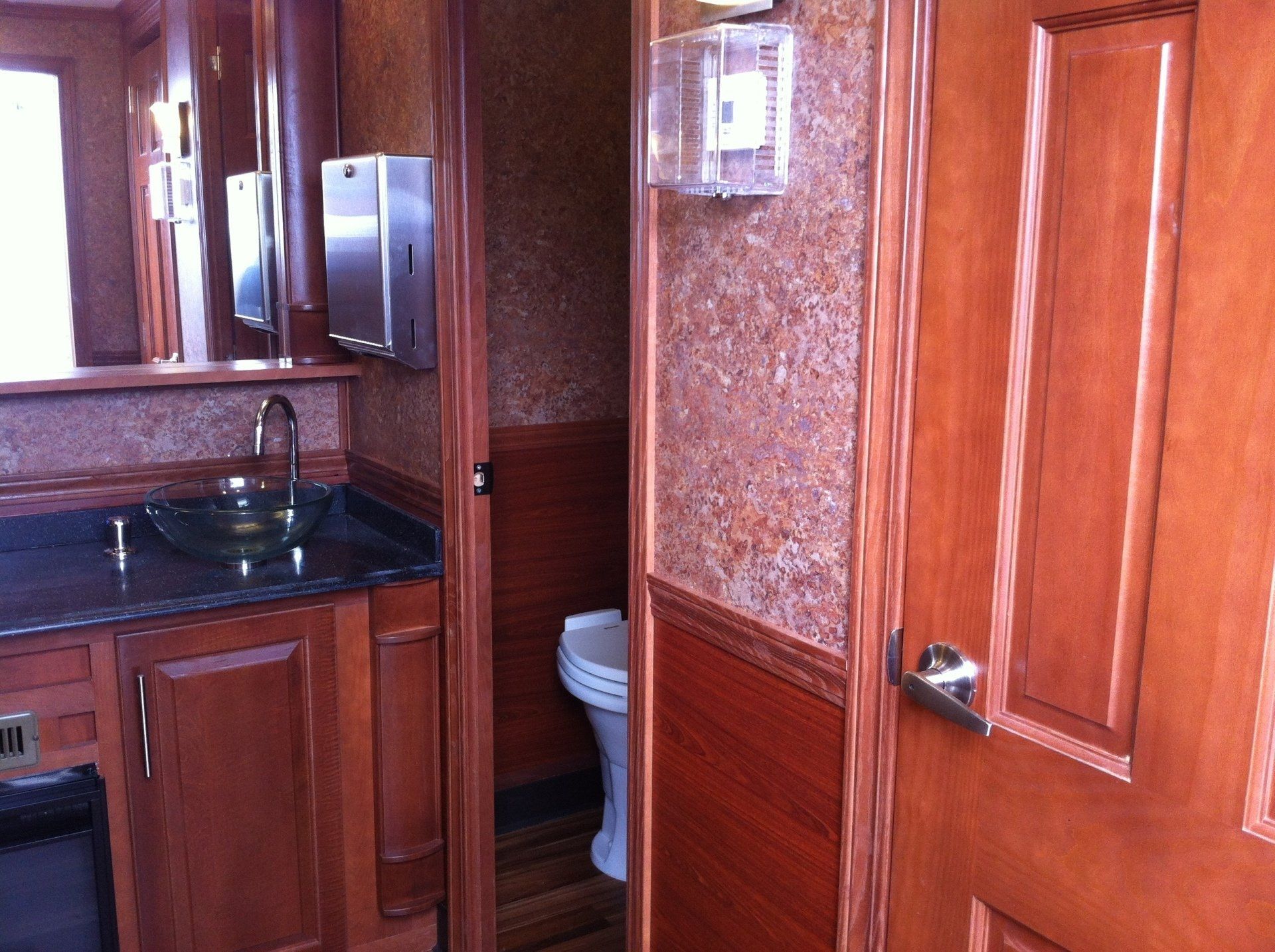 A bathroom with wooden cabinets and a toilet