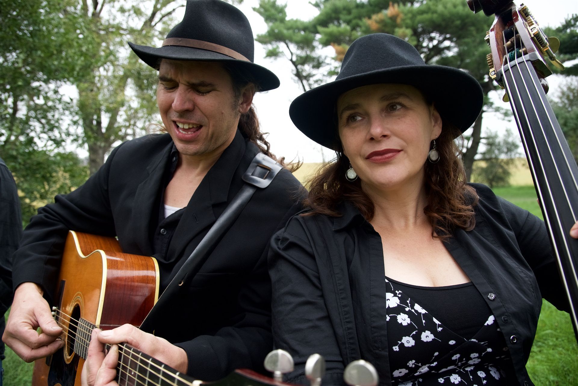 A man with dreadlocks and a beard is sitting in a tree.