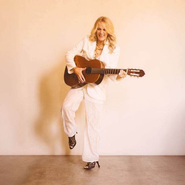 woman standing playing a guitar