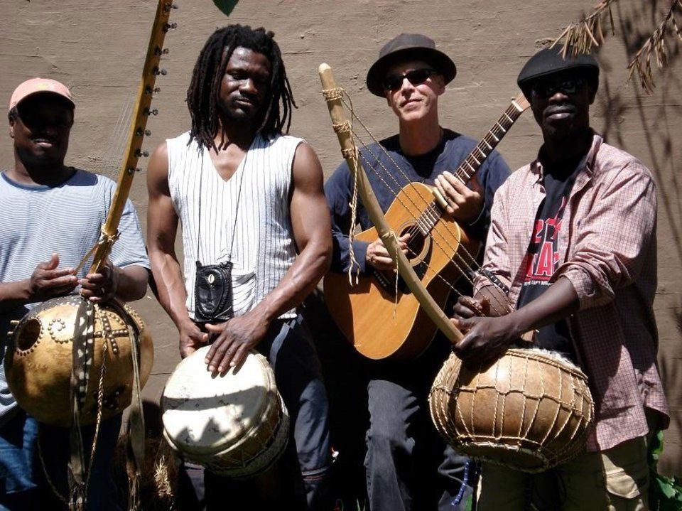 A group of men playing musical instruments including drums and guitars