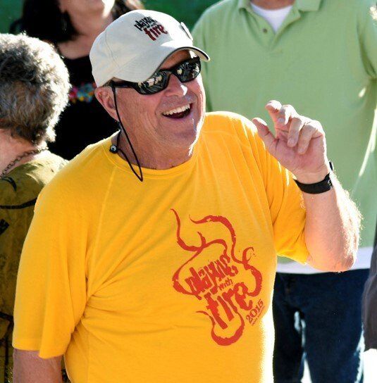 A man wearing a yellow shirt that says always fire