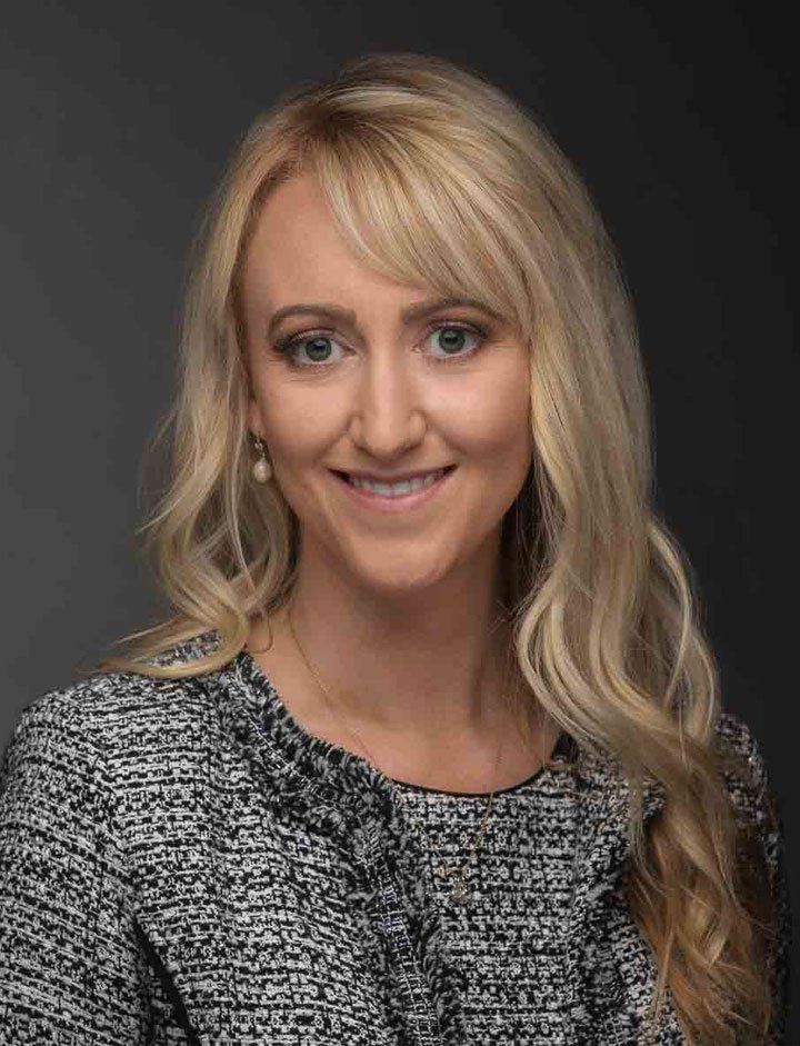 A woman with long blonde hair is smiling for the camera.
