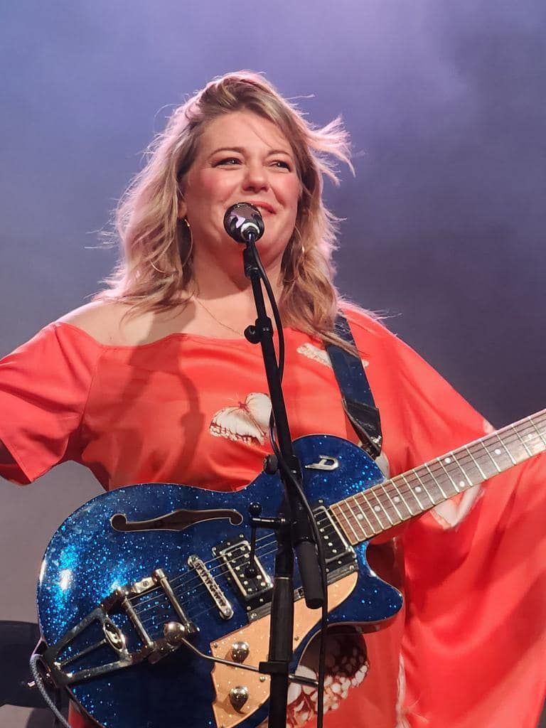 Woman smiling sitting alone in front of window 
