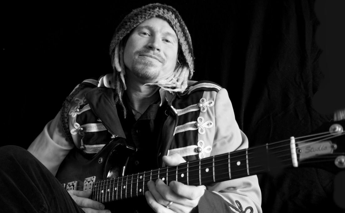 A man is playing a guitar in a black and white photo.