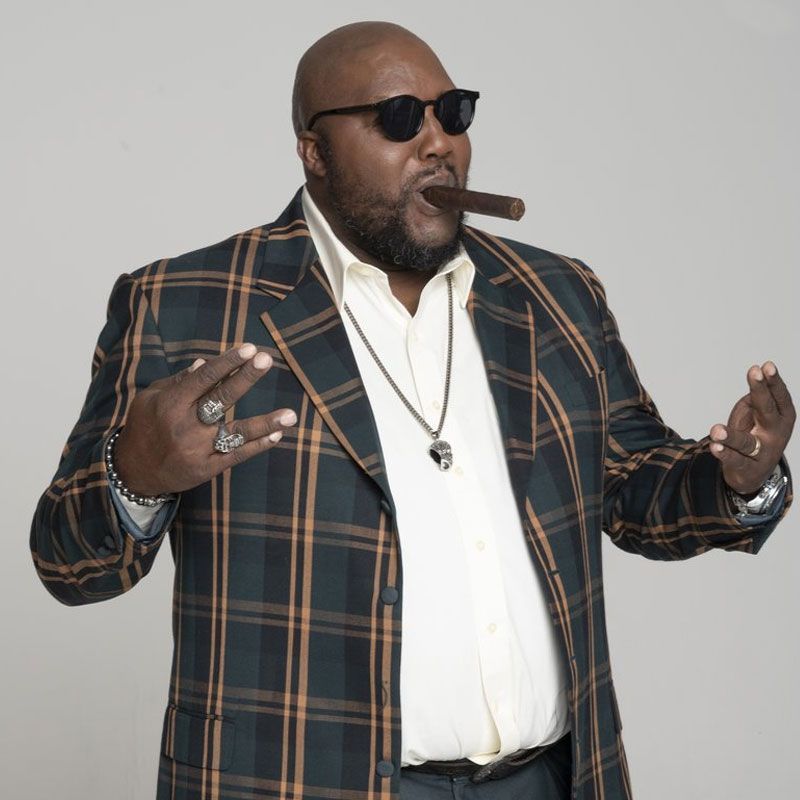 Image may contain bearded man, sun glasses, cigar and pendant.