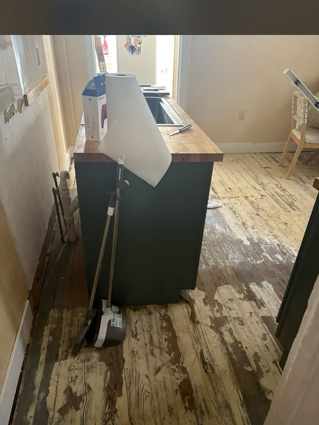 A kitchen under construction with white cabinets and a dishwasher.