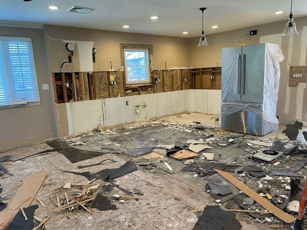 a kitchen is being remodeled with a refrigerator in the middle of the room .