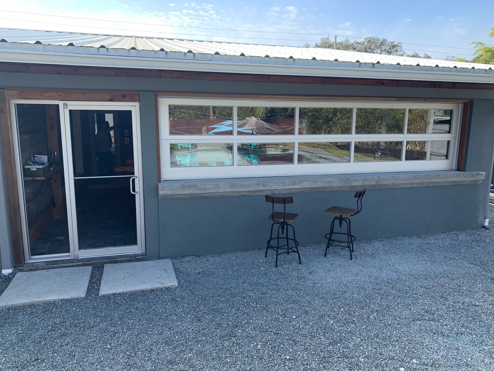 A house with a large garage door and two stools in front of it.