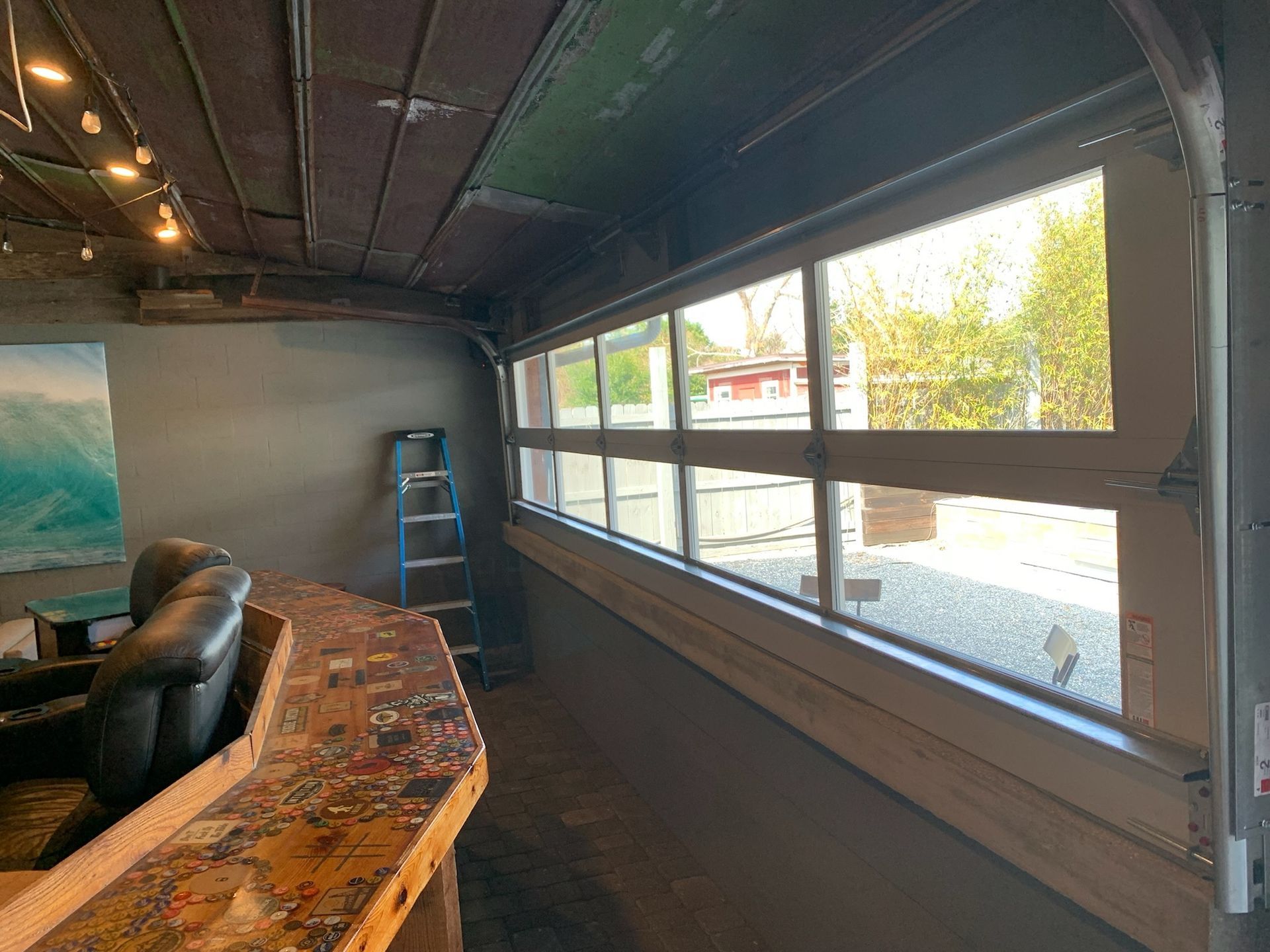 A large window in a room with a bar and a ladder.