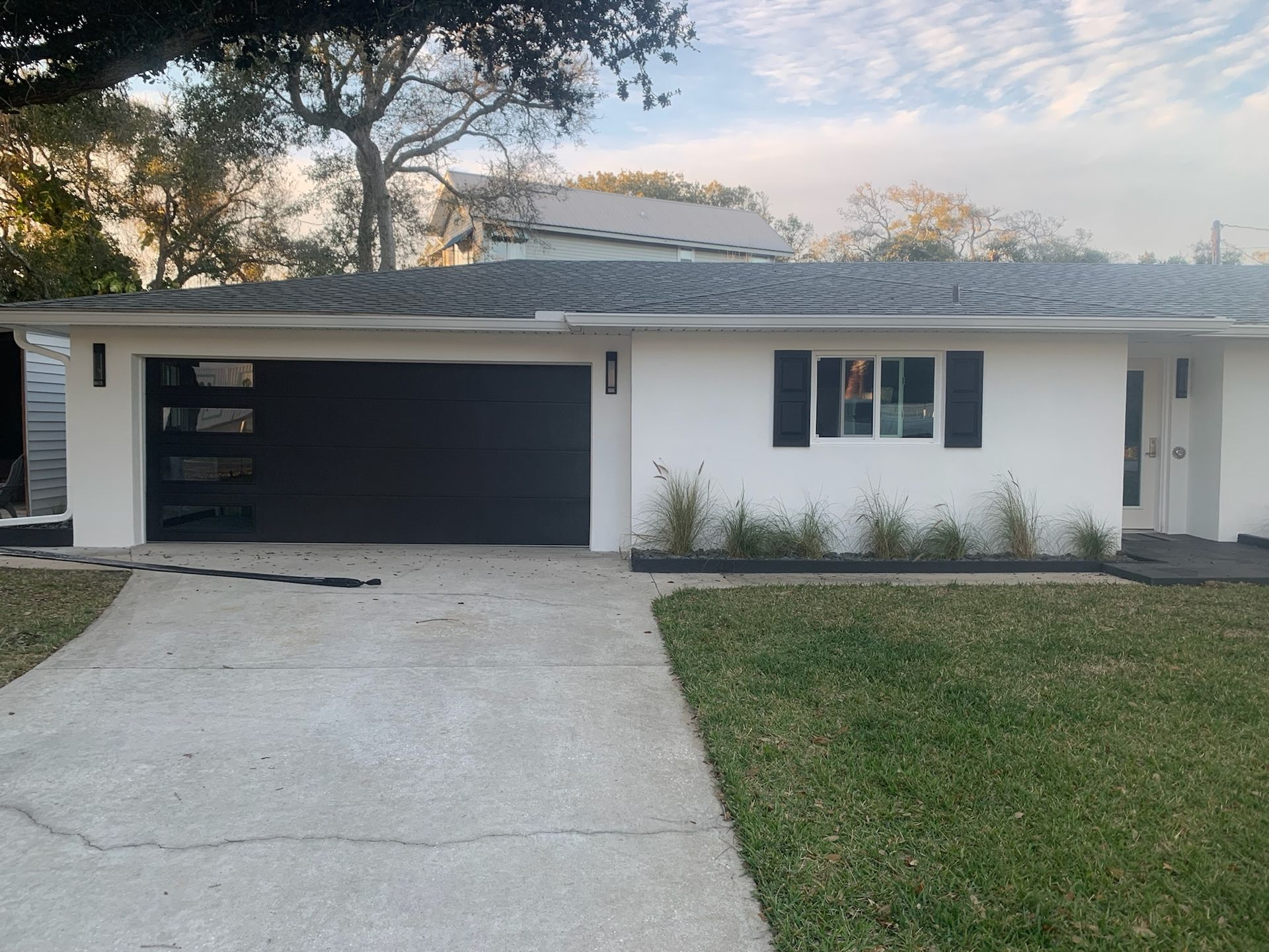 A white house with a black garage door