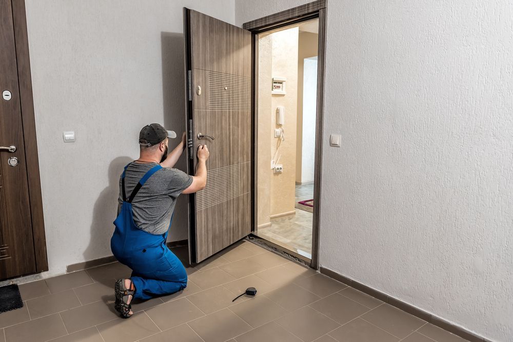 A man is kneeling down in front of a door.