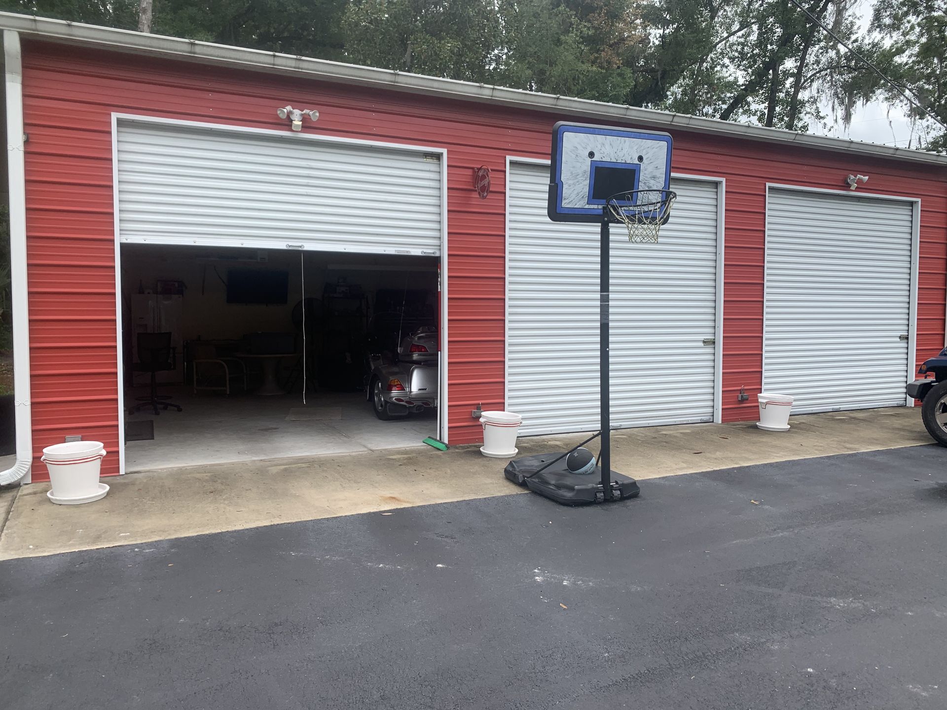 A basketball hoop is sitting in front of a garage.