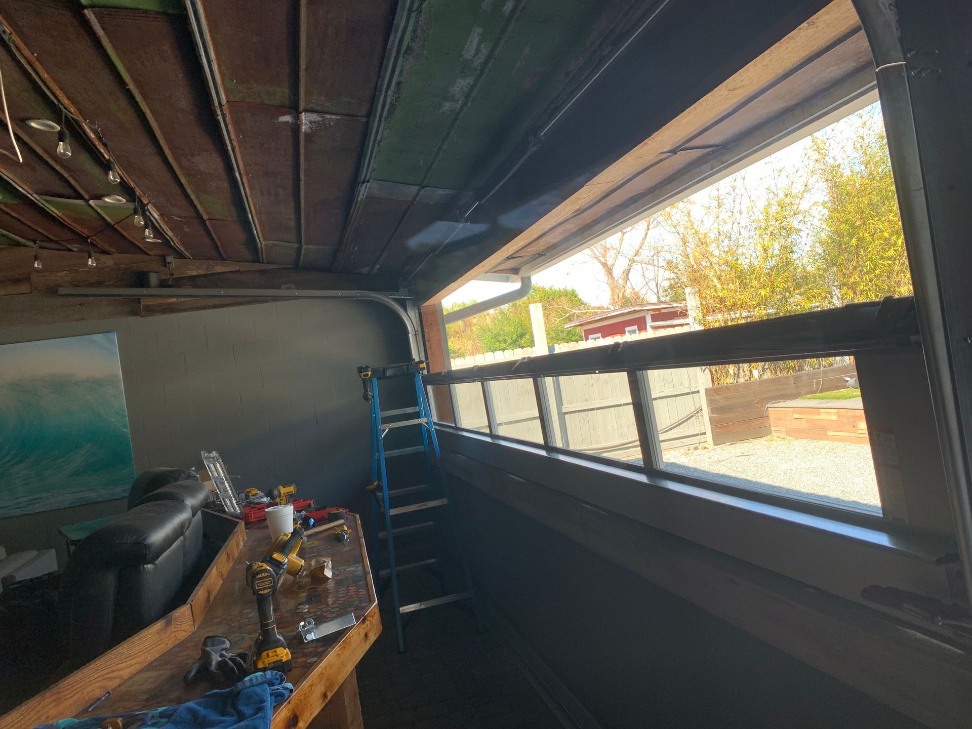 A large window in a room with a ladder.