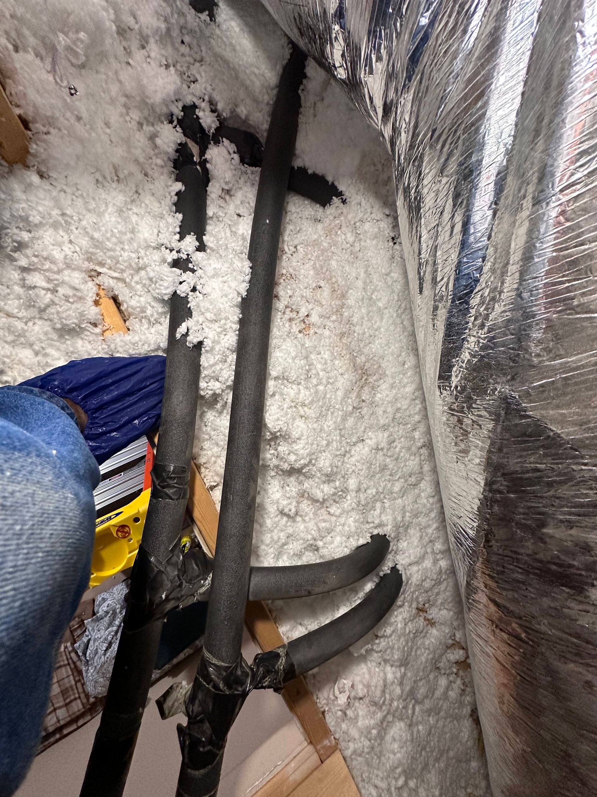 A person is standing in a room with a bunch of wires hanging from the ceiling.