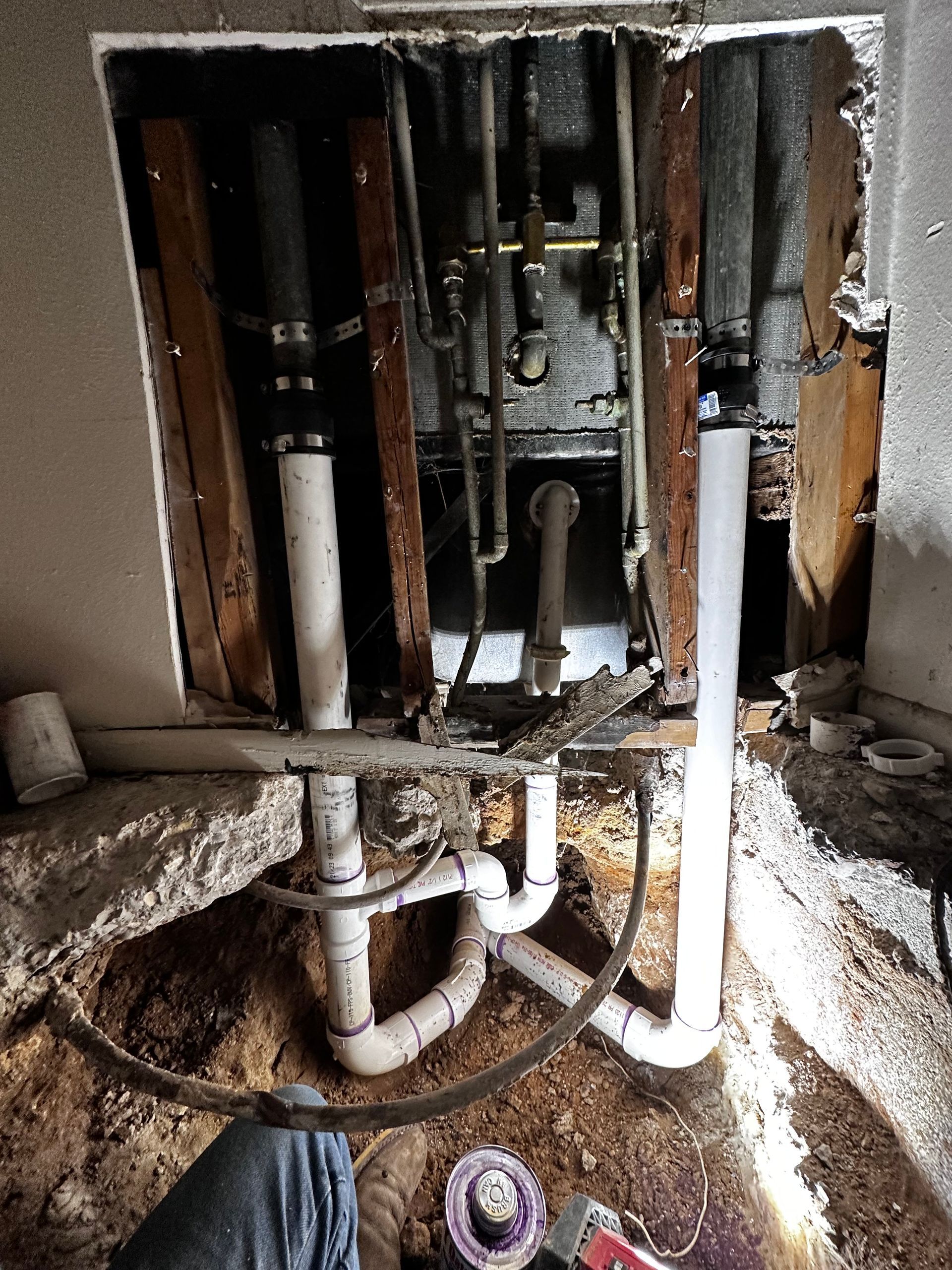 A hole in a wall with pipes coming out of it