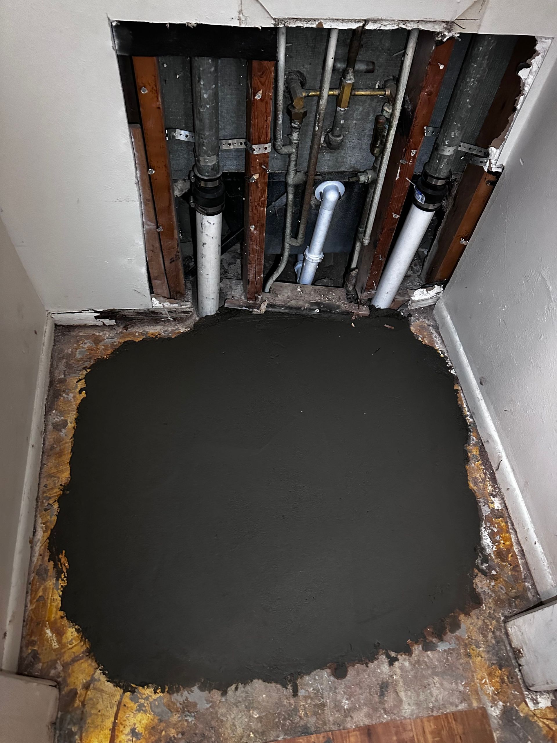 A hole in the wall is being filled with concrete