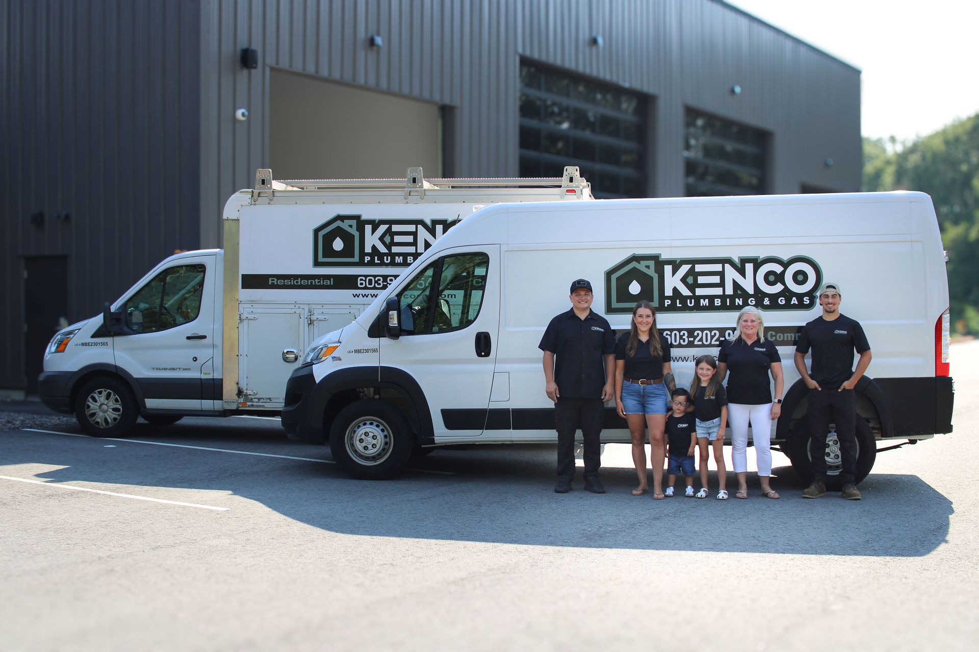Group of people standing with Kenco Property Team vans in front of a building.