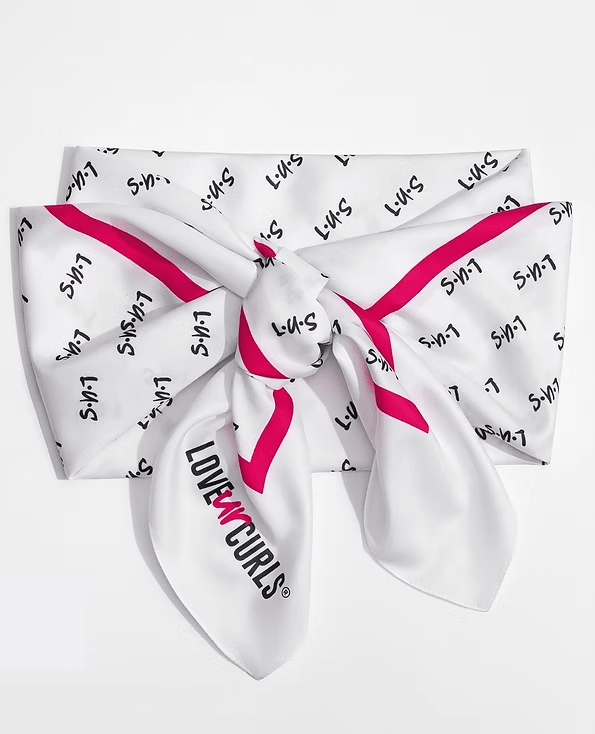 White scarf with pink trim, tied in a knot. "Love n' Curls" logo on the front. S-H-7 text.