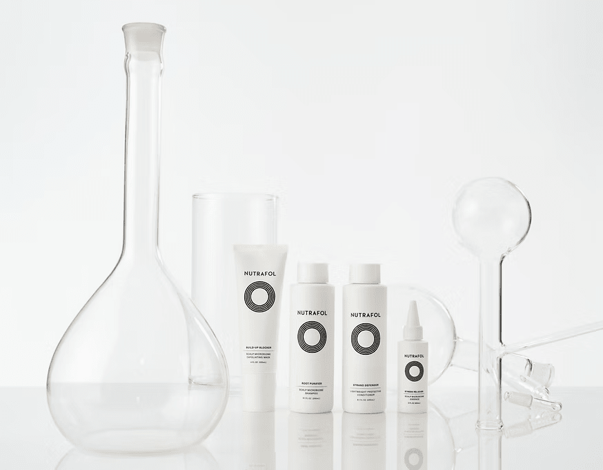 Glass lab equipment and skincare products on white background.
