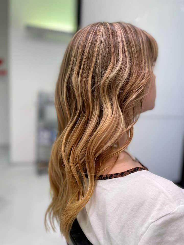 Una donna con lunghi capelli biondi è seduta su una sedia in un salone.