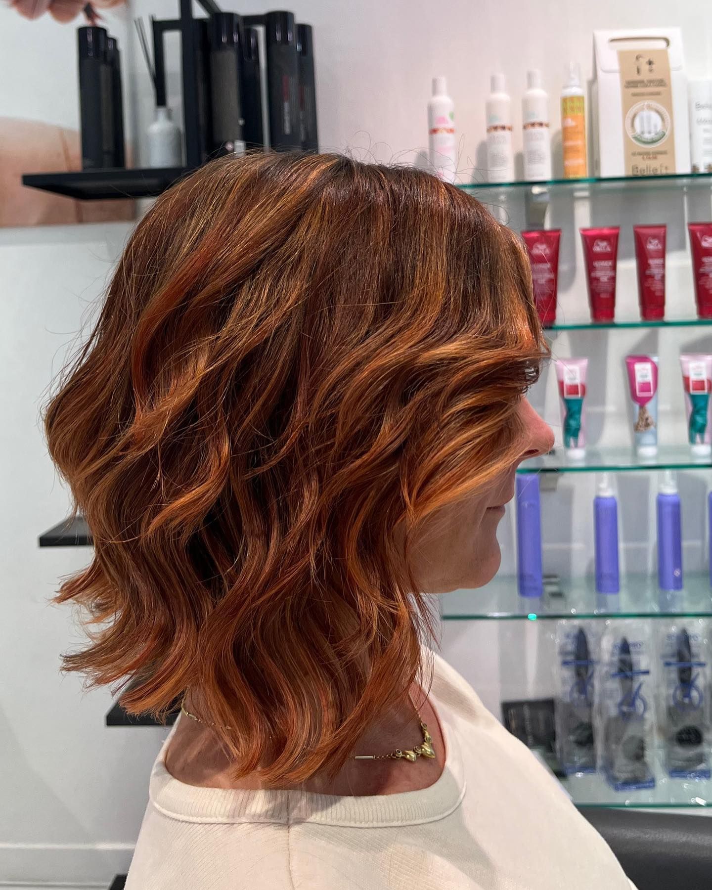 Una donna con i capelli rossi si sta tagliando i capelli in un salone