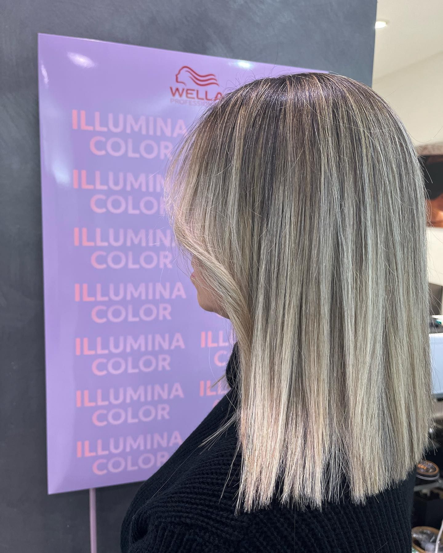 Una donna è in piedi davanti a un cartello che dice colore illumina