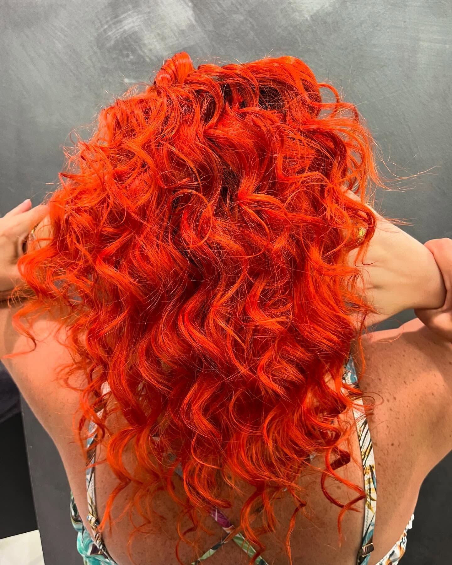 La schiena di una donna con i capelli rossi e ricci