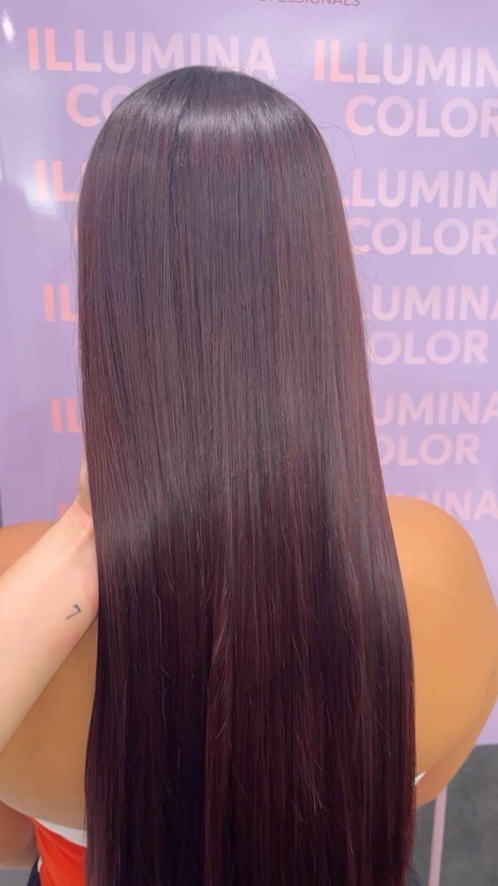 Una donna con i capelli lunghi è seduta davanti a un cartello che dice illumina color