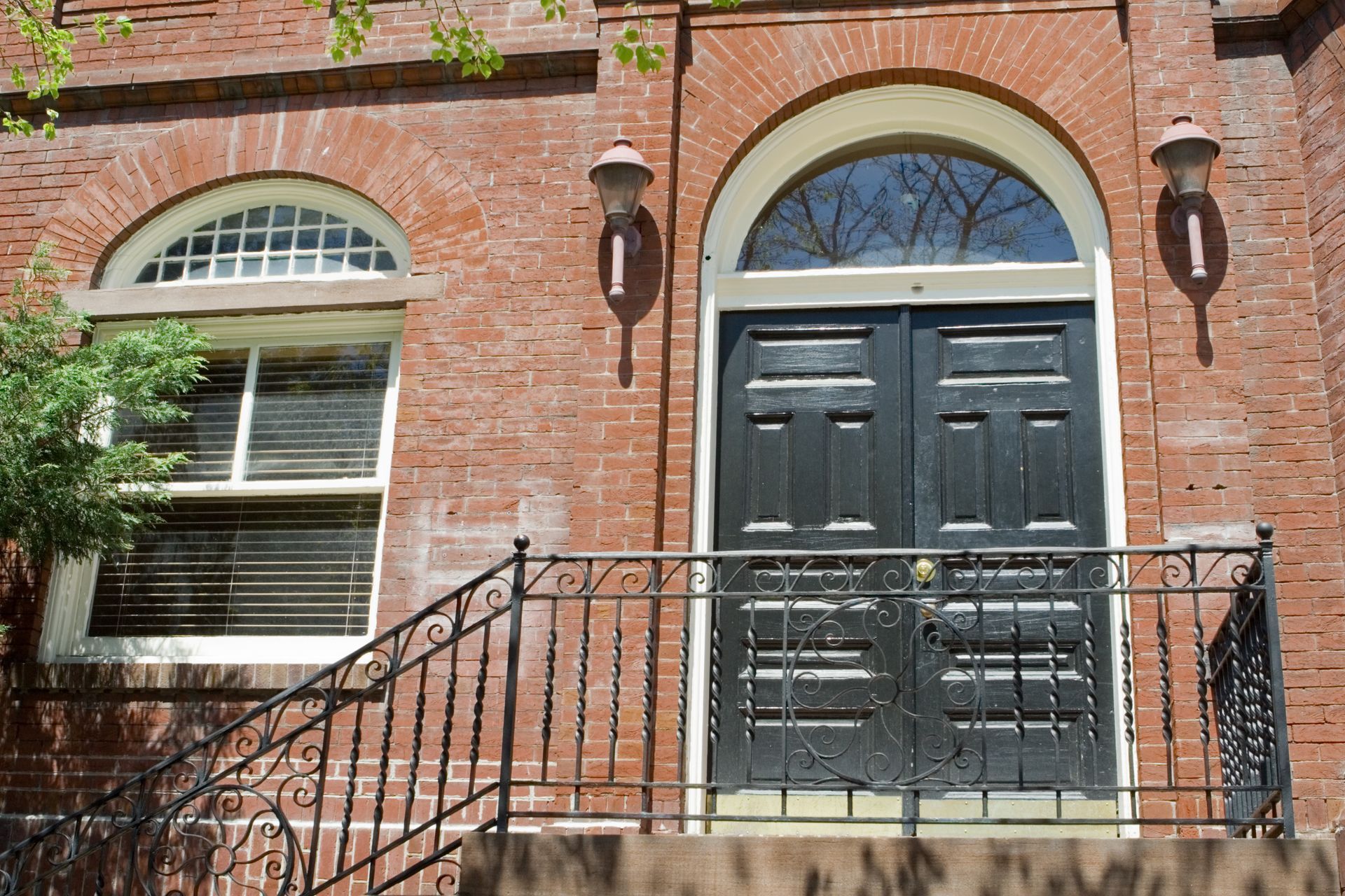 A brick building with a black door and two windows