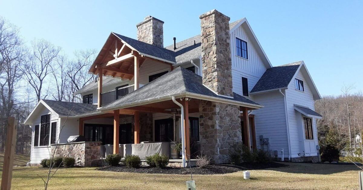 A man is kneeling down on a tiled roof.