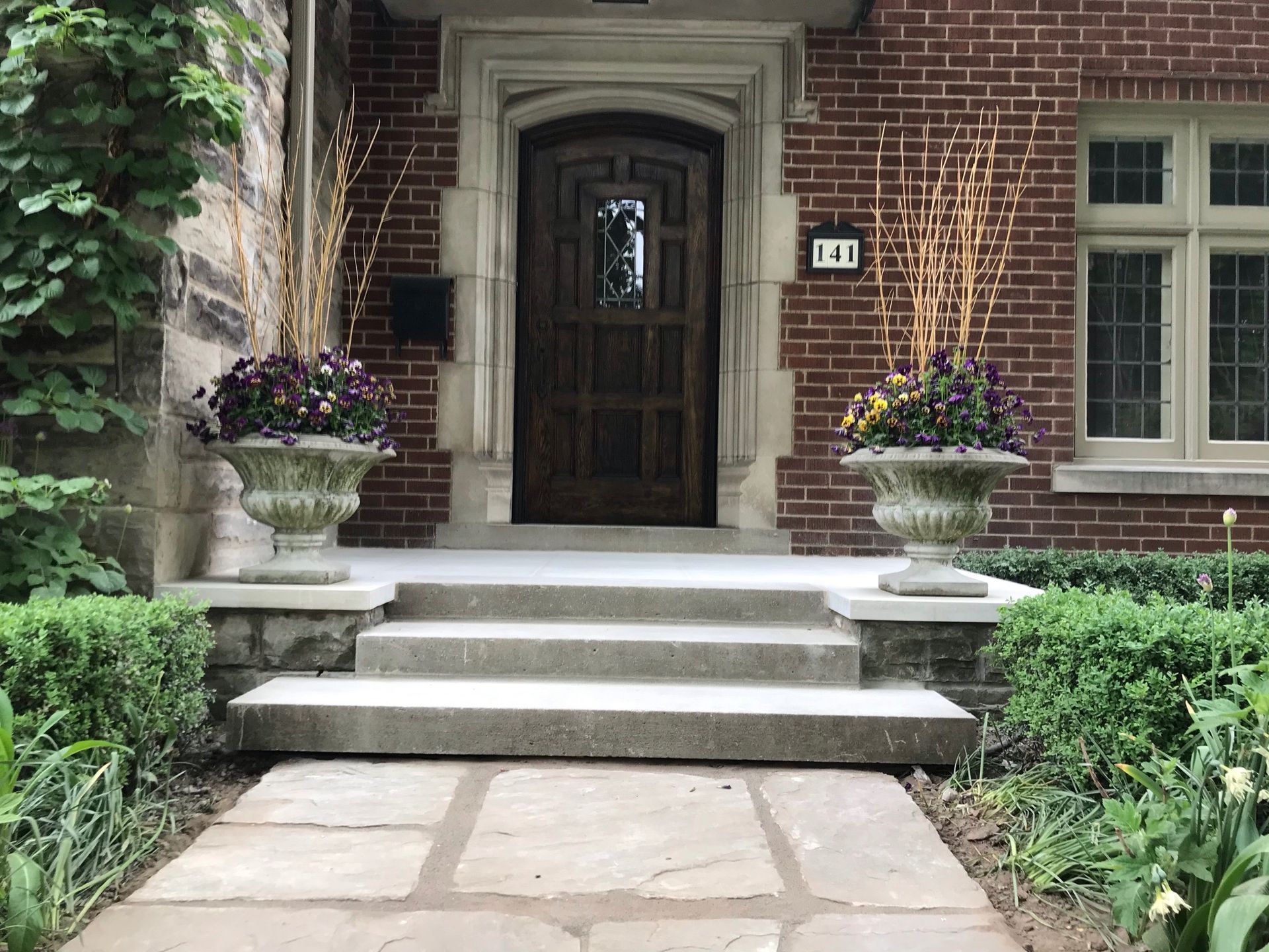 A brick house with a stone walkway leading to the front door.