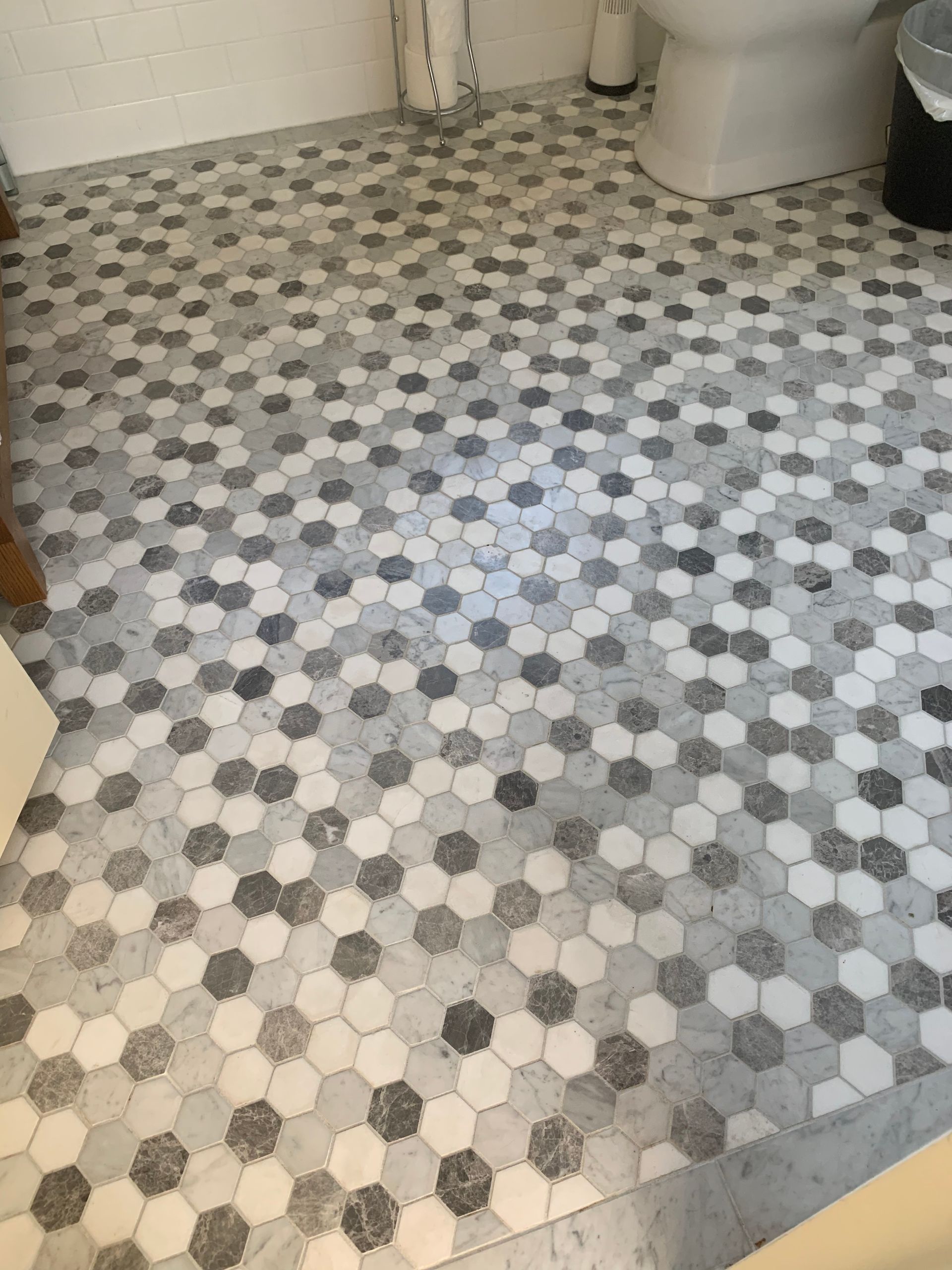 Bathroom floor tiled with gray and white hexagonal tiles.