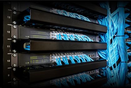 A server rack with a lot of blue wires coming out of it